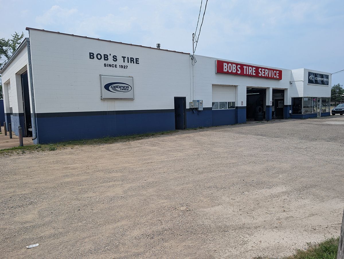 Exterior of Bob’s Tire shop with white and blue building and red storefront sign on a gravel lot