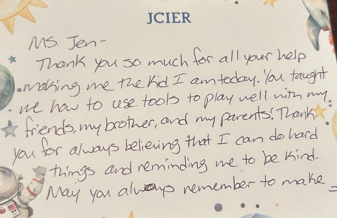 Handwritten thank-you note on lined paper with blue ink and a faint floral border.