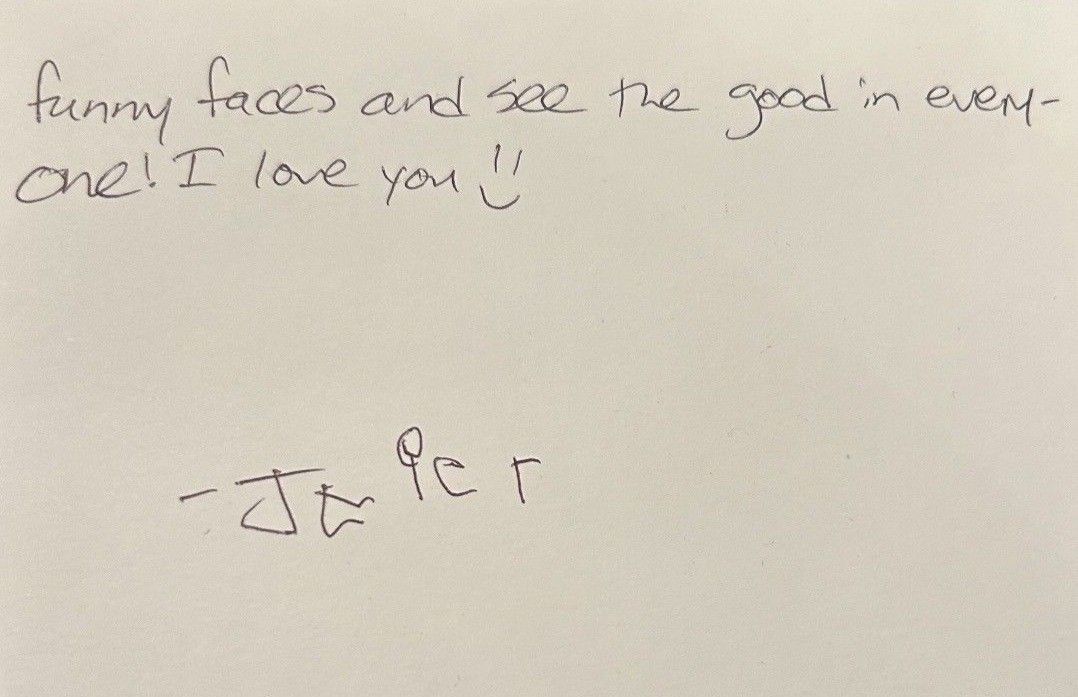 Handwritten note on white paper with a short message and a small scribble below.