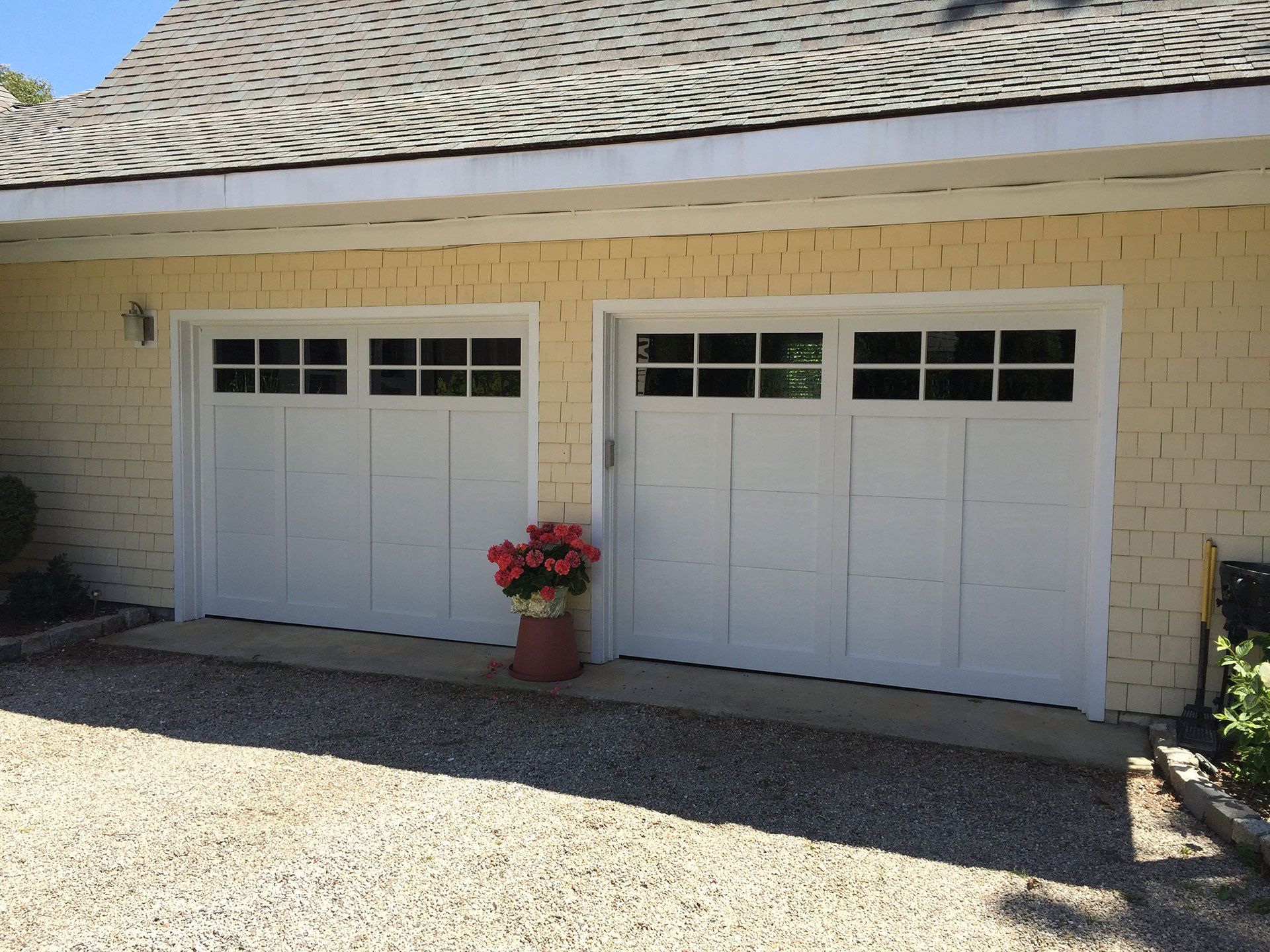 two garage doors with flowers between