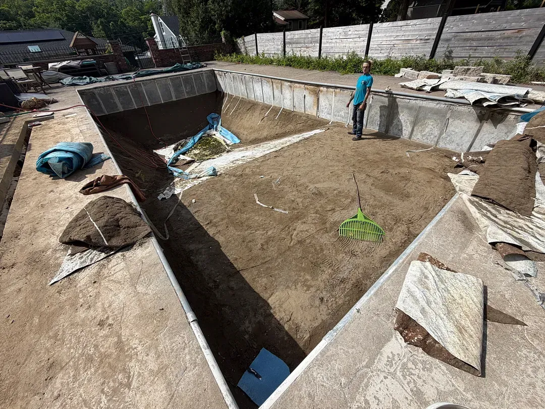 Workers building a concrete foundation trench at an outdoor construction site