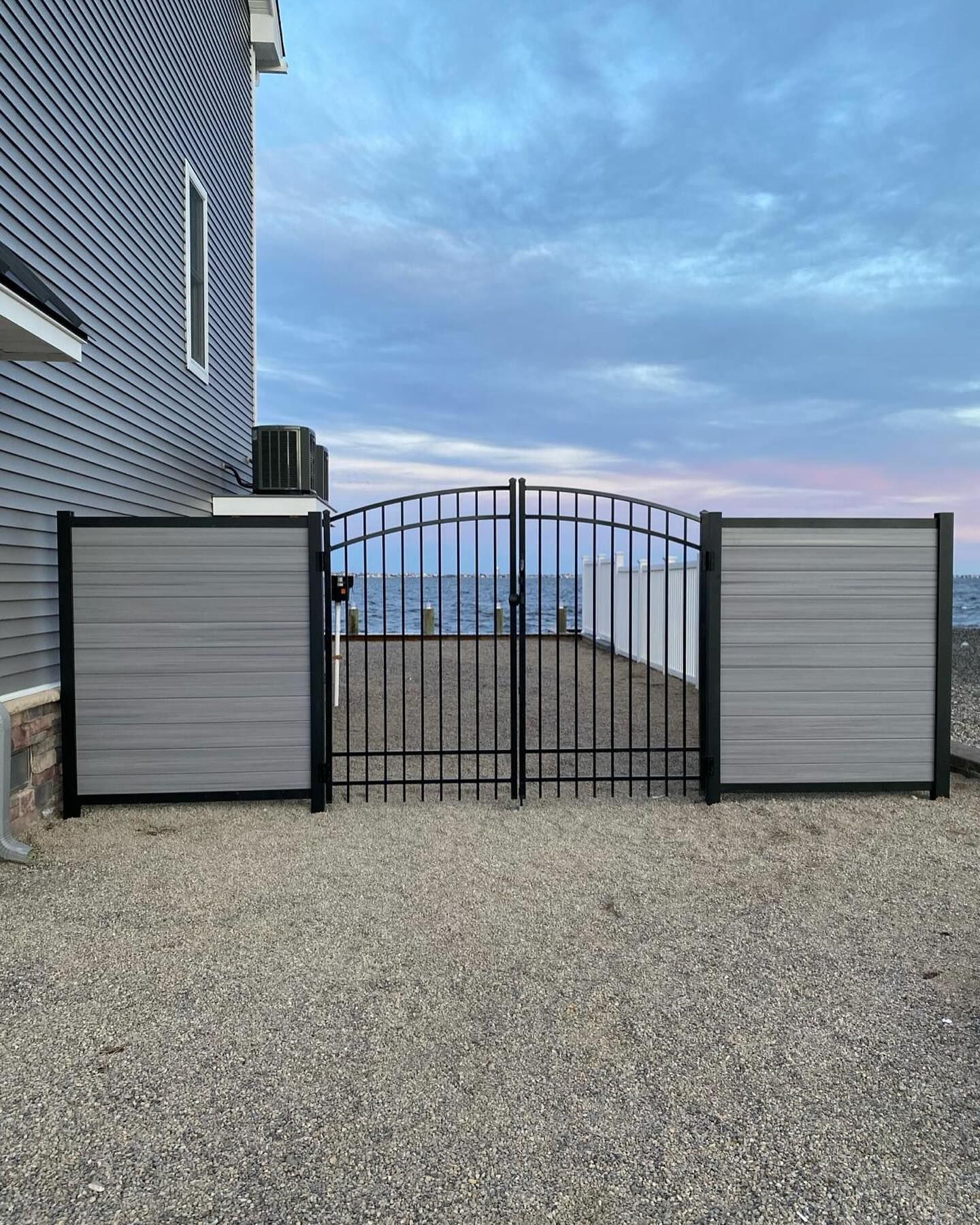 there is a gate in front of a house with a view of the ocean .