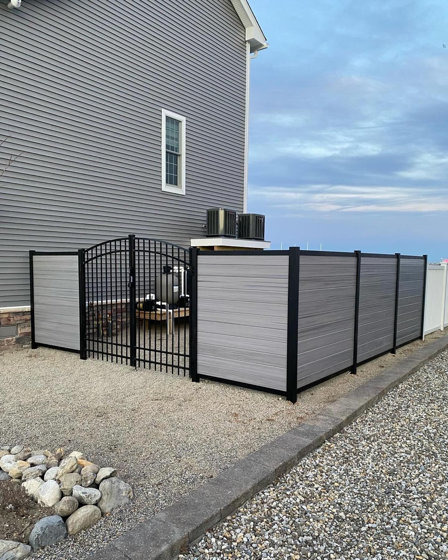 a fence is surrounding a patio area in front of a house .