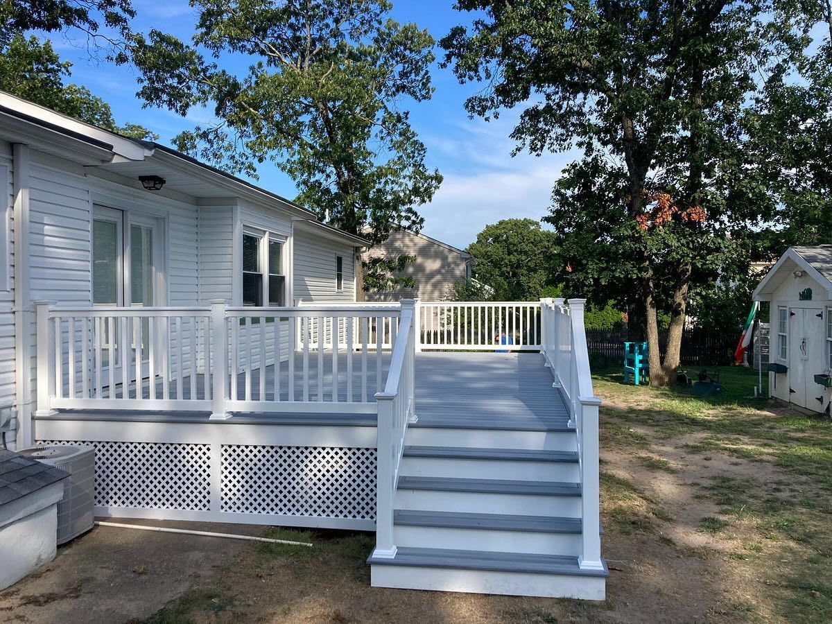 A white house with a large deck and stairs