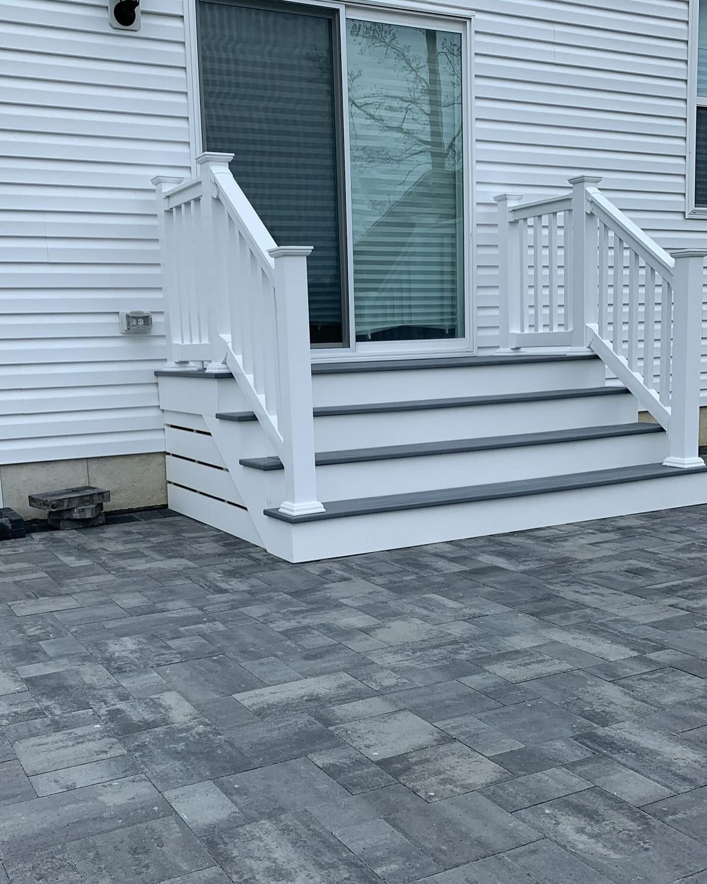 A white house with stairs and a white railing