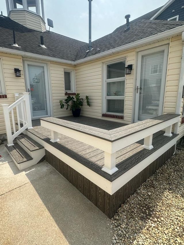 A house with a deck and stairs in front of it.