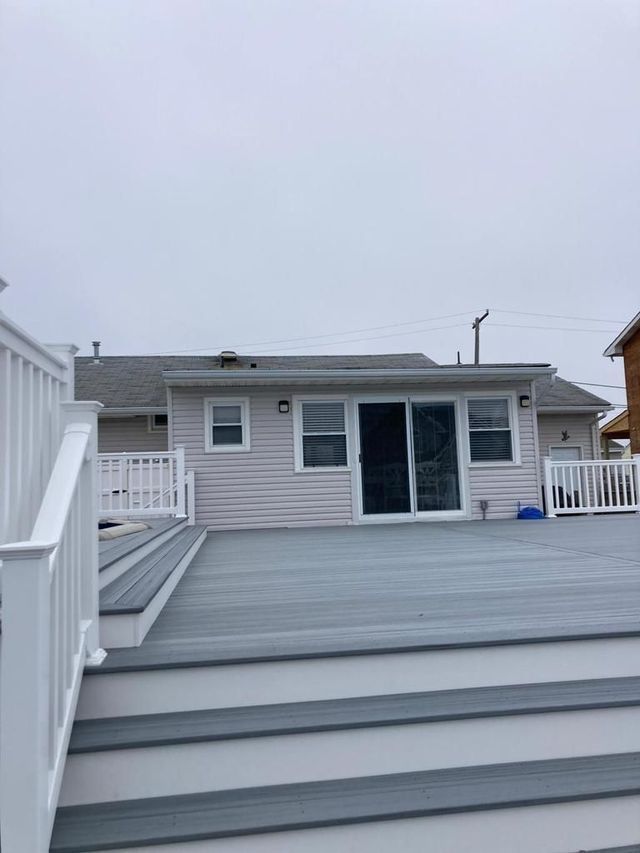 There is a deck with stairs leading to the back of the house.