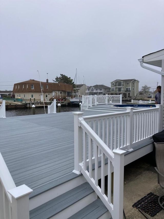 A deck with a white railing overlooking a body of water.