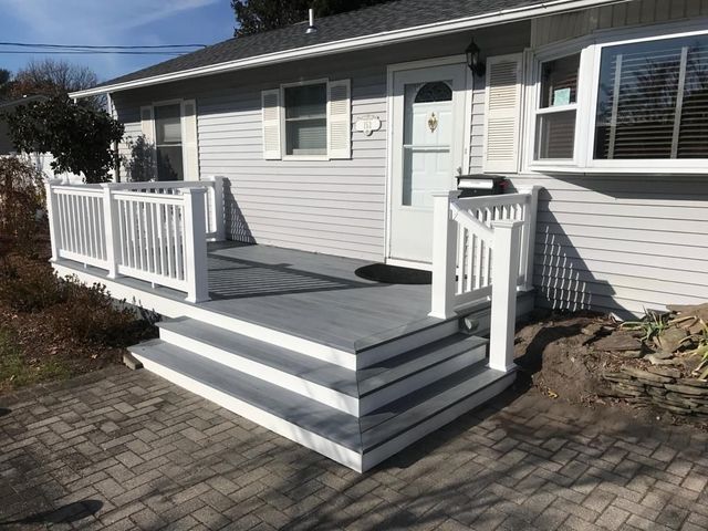 A house with a porch and stairs in front of it.