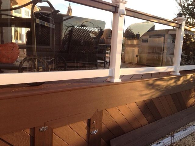 A deck with a white railing and a glass railing.