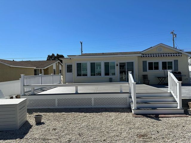 The back of a house with a large deck and stairs.