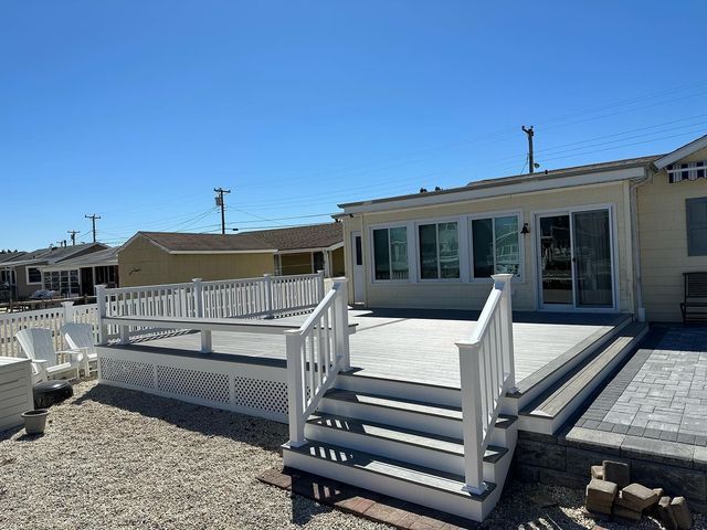 A house with a large deck and stairs in front of it.