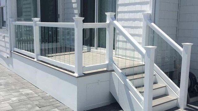 A white deck with stairs and a white railing.