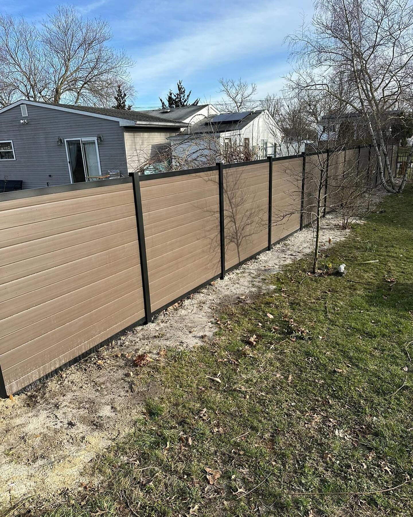 A wooden fence is sitting in the middle of a grassy field.