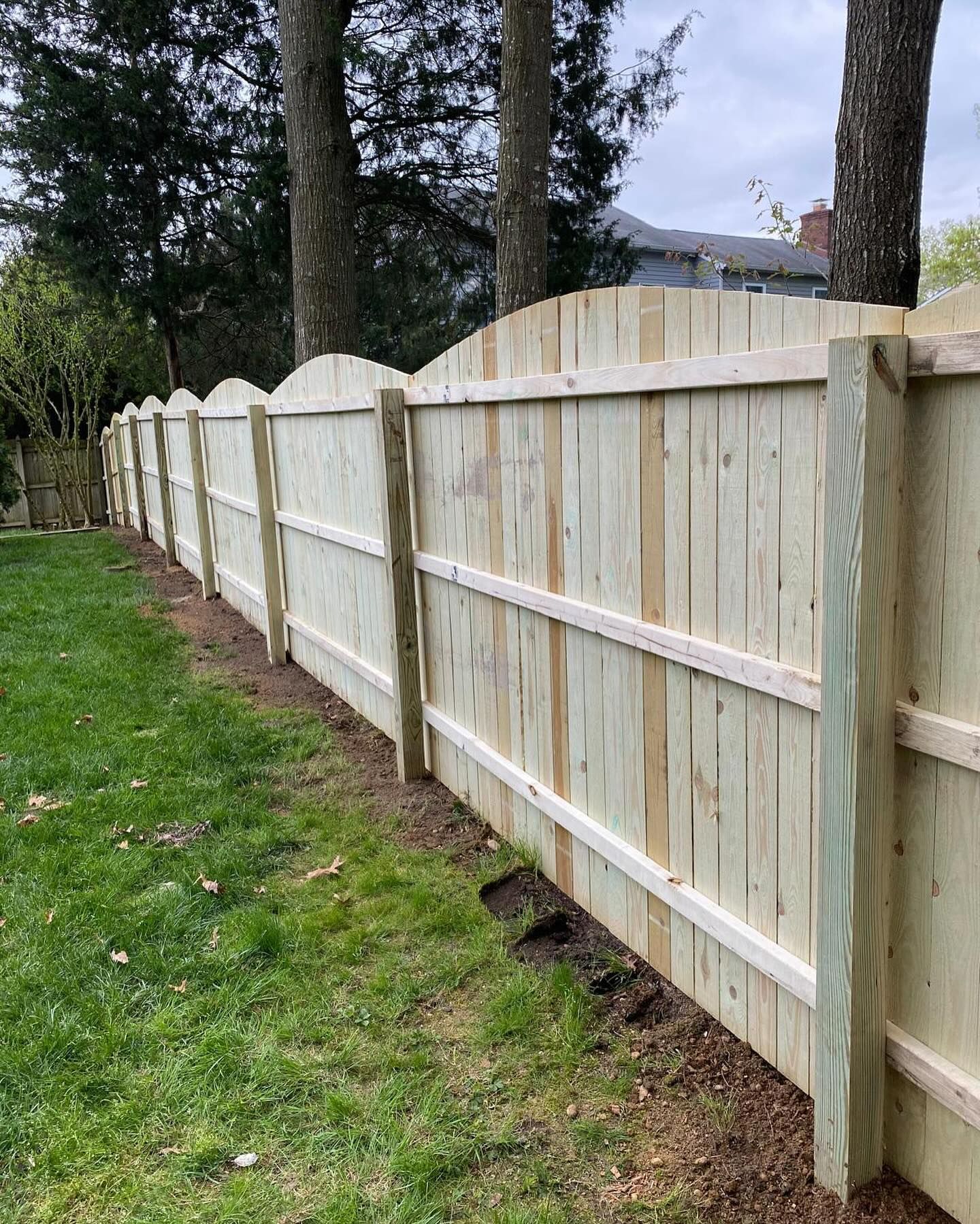 A wooden fence is sitting in the middle of a lush green field.