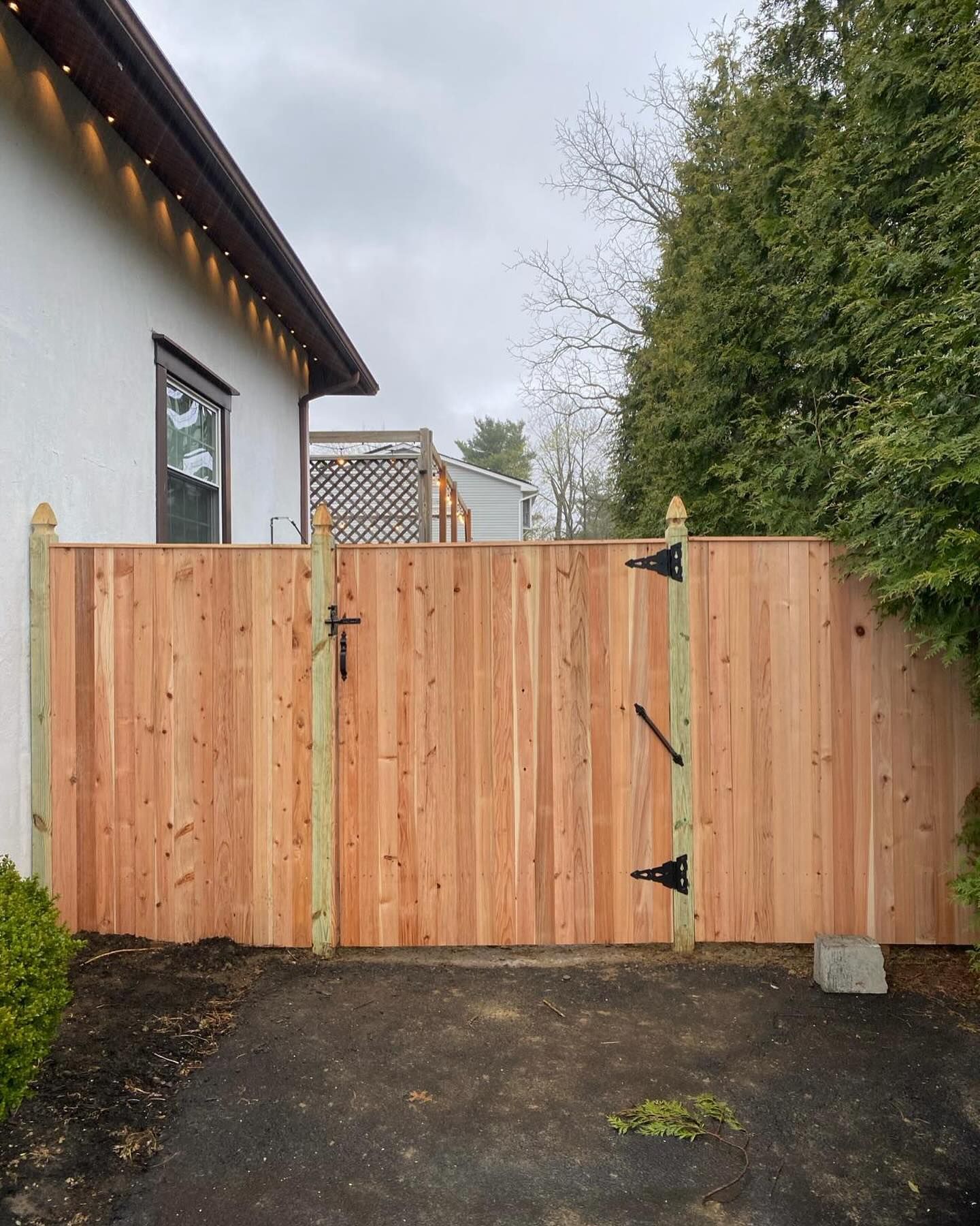 A wooden fence with a gate in front of a house