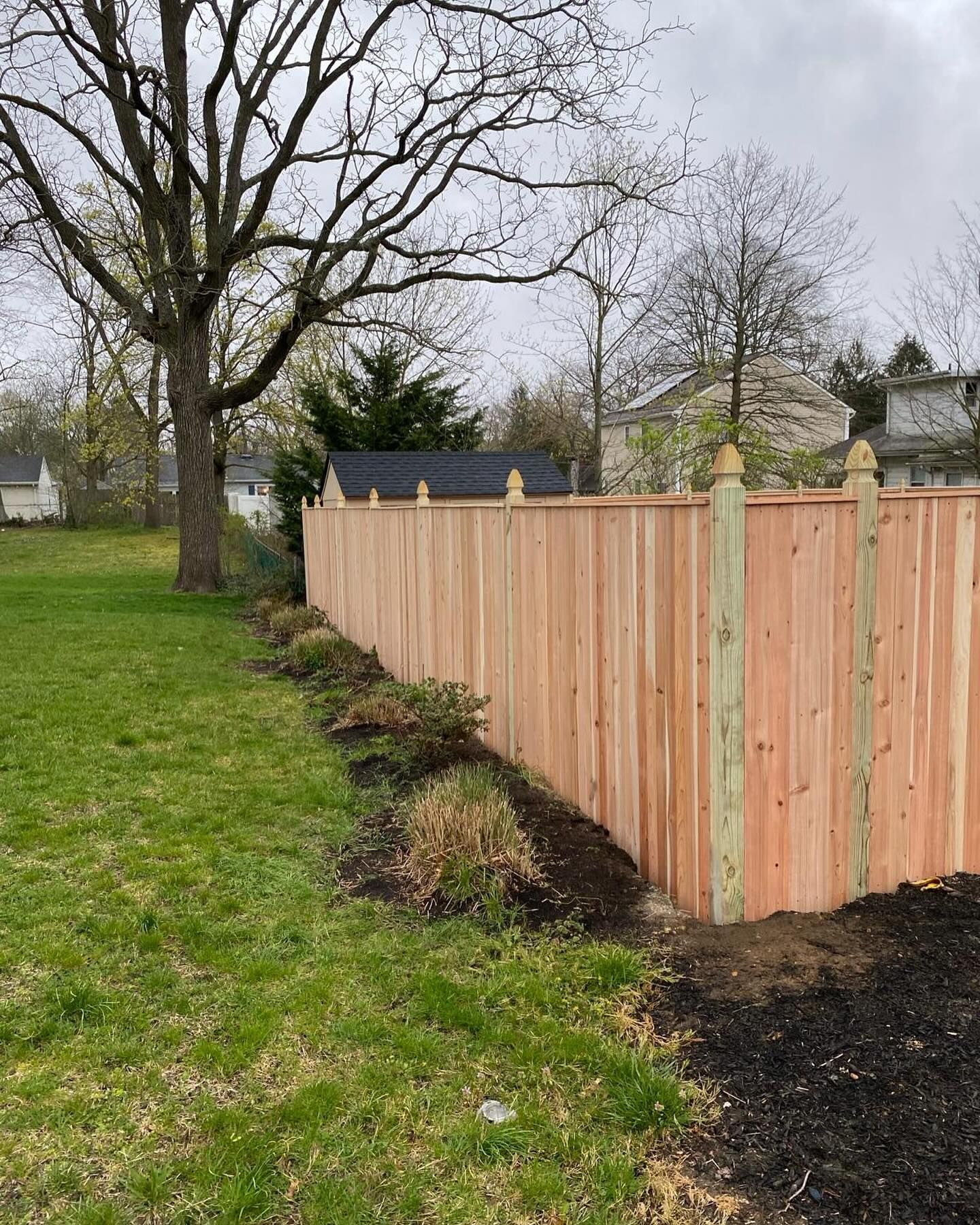 A wooden fence is sitting in the middle of a lush green field.