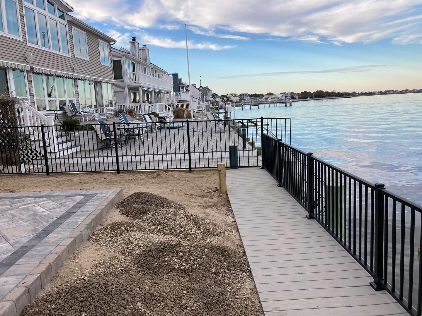 A walkway leading to a body of water with a fence surrounding it.