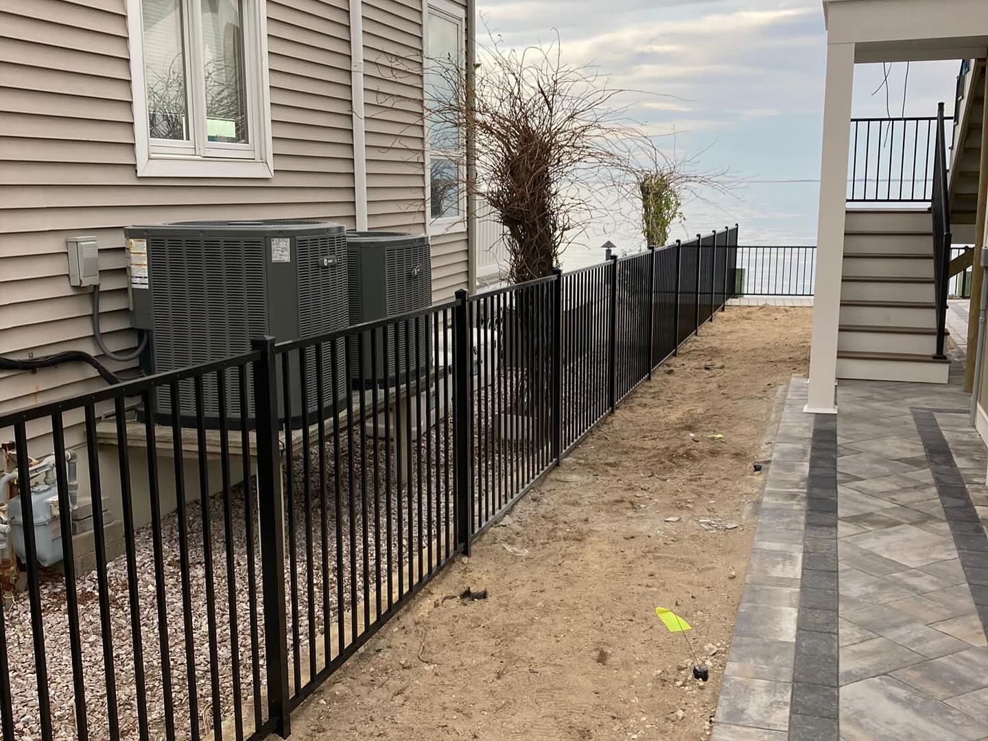 An aluminum fence surrounds a house with a view of the ocean.