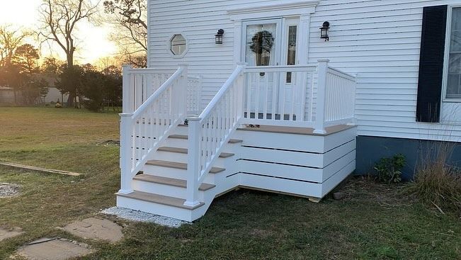 A white house with a porch and stairs.
