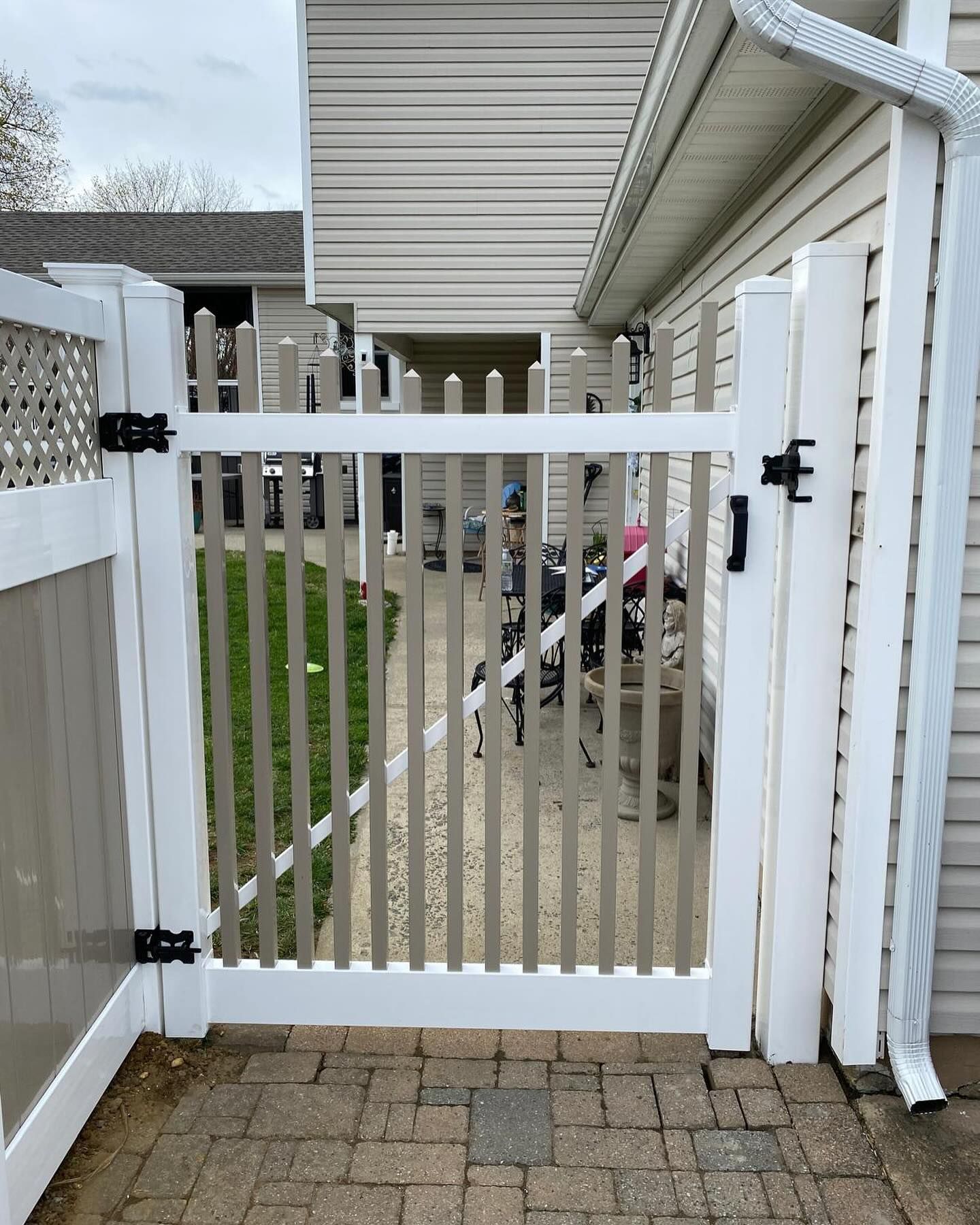 A white fence with a gate in front of a house.