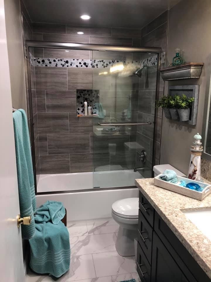 A bathroom with a toilet , sink , bathtub and shower.
