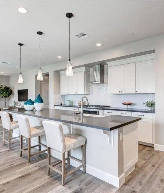 A kitchen with white cabinets and a large island