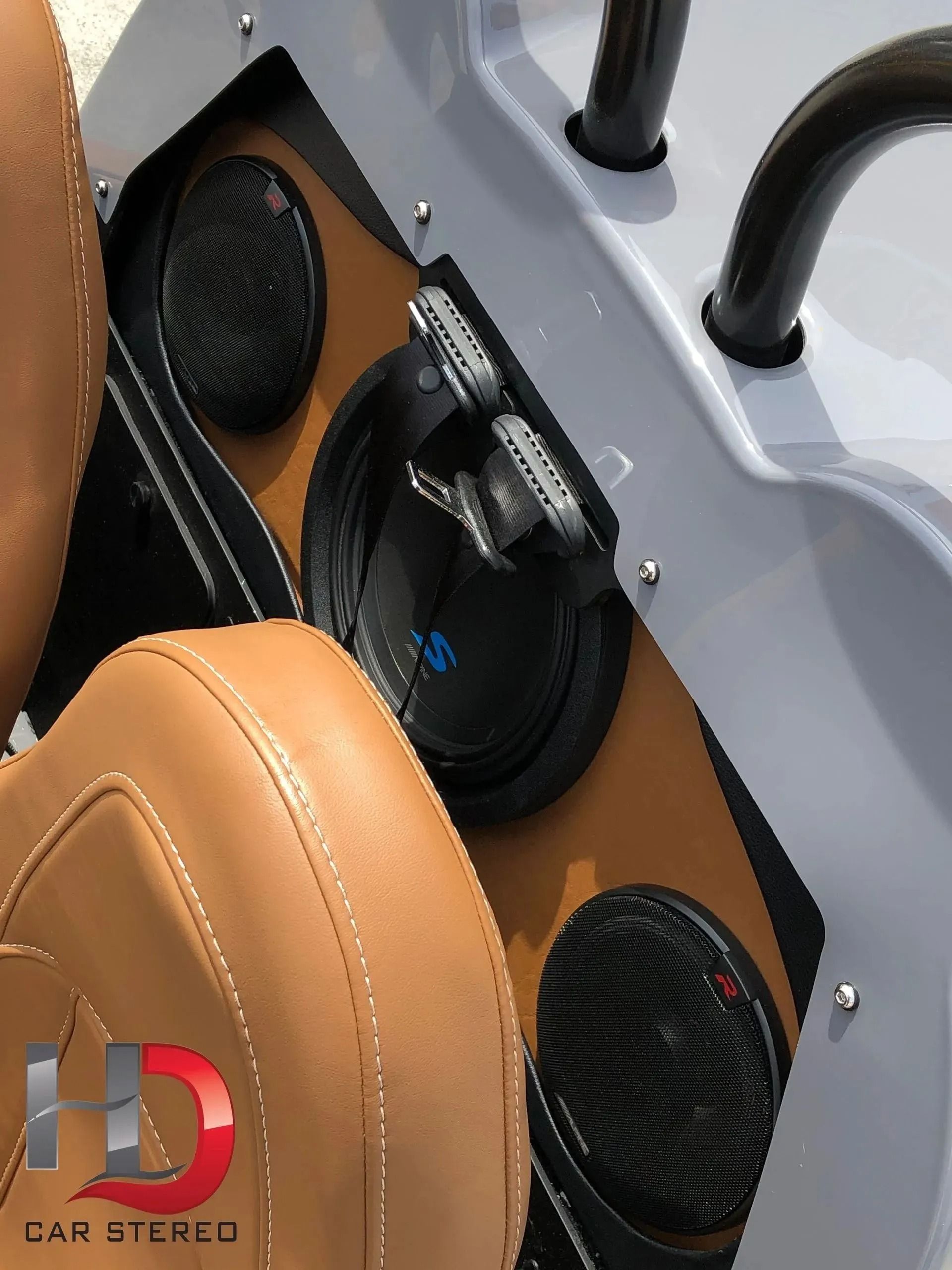 Custom car stereo with tan leather seats and speakers installed.