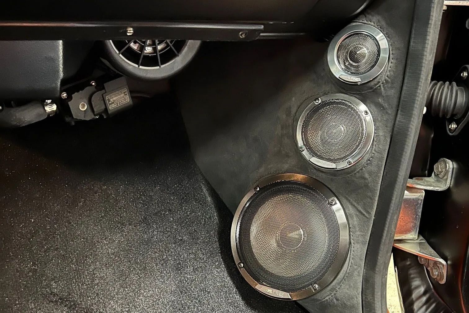 Three round car speakers mounted on a black panel.