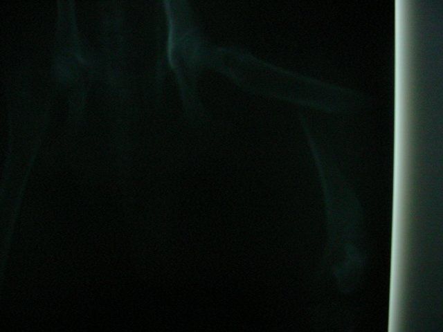 Smoke is coming out of a window in a dark room.