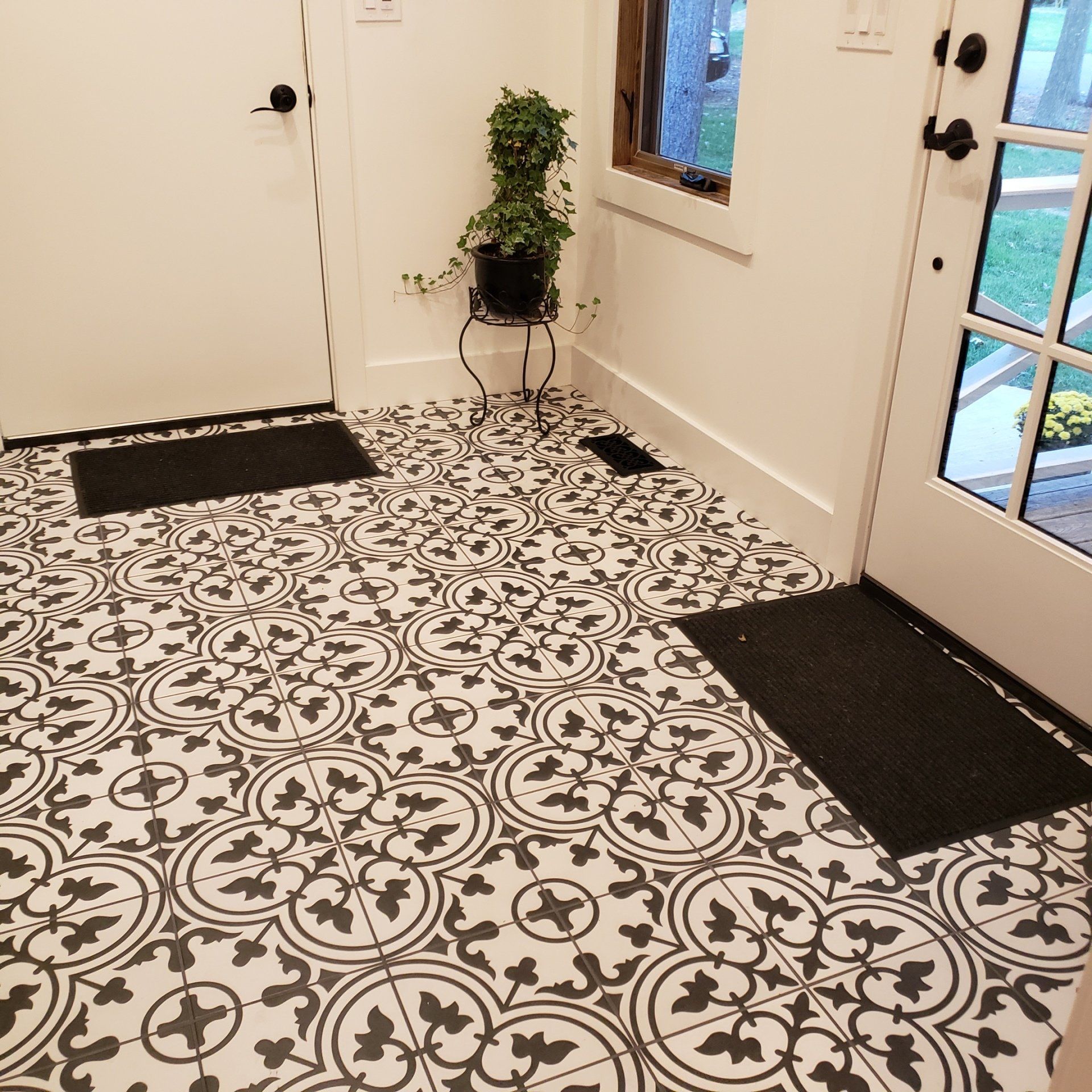 A black and white tile floor in a hallway next to a door
