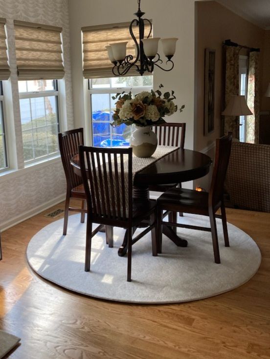 A dining room table with a vase of flowers on it
