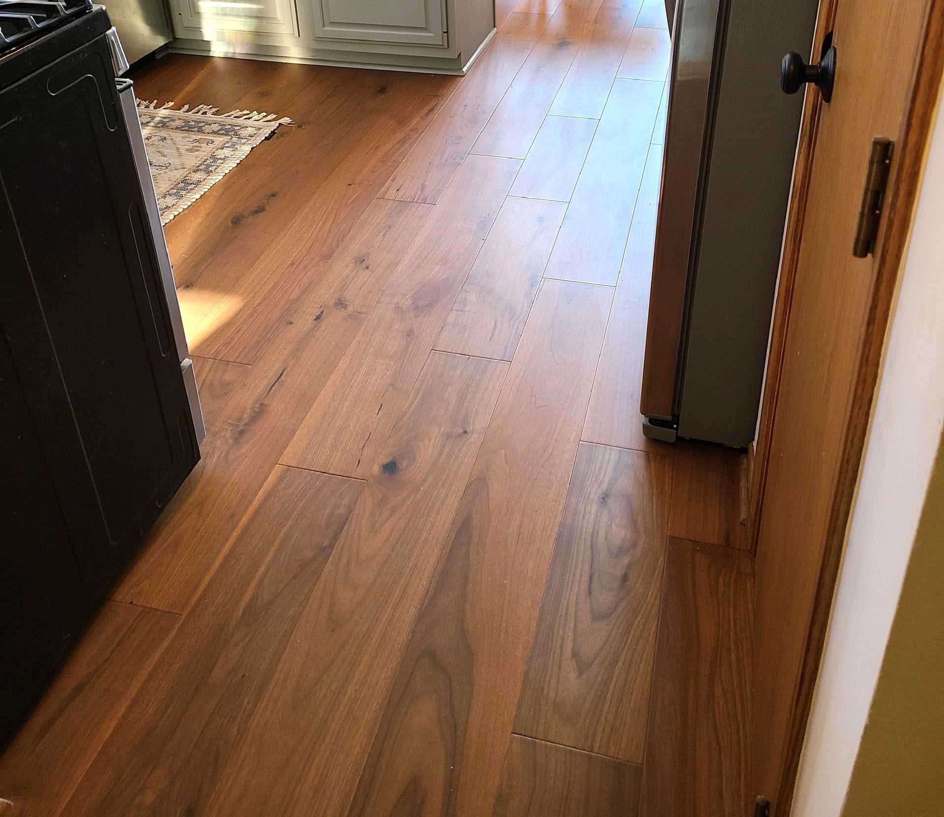 A kitchen with hardwood floors and a refrigerator