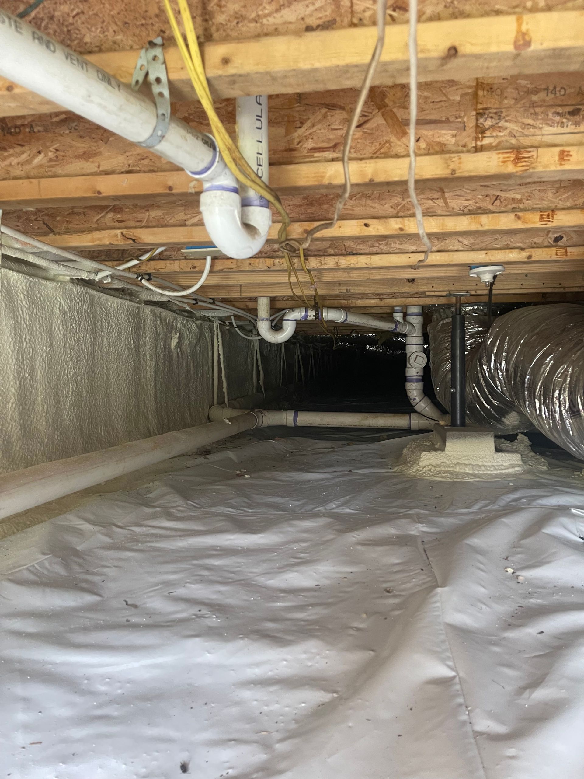 A basement with a lot of pipes and ducts.