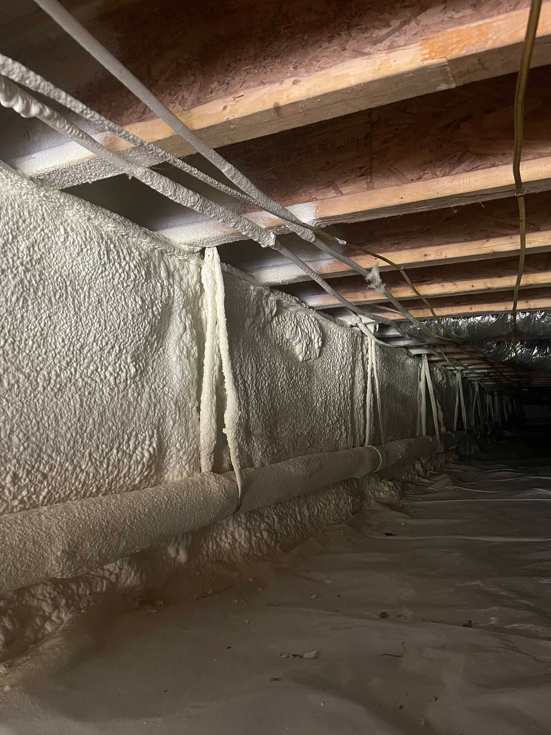 A crawl space with a lot of foam on the walls and ceiling.