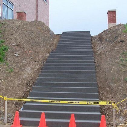 Blocked outdoor stairs under construction, taped off with caution tape and orange cones.