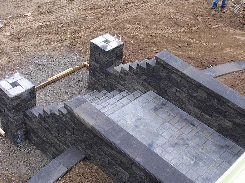 Stone stairway with dark gray brick walls and steps under construction outdoors