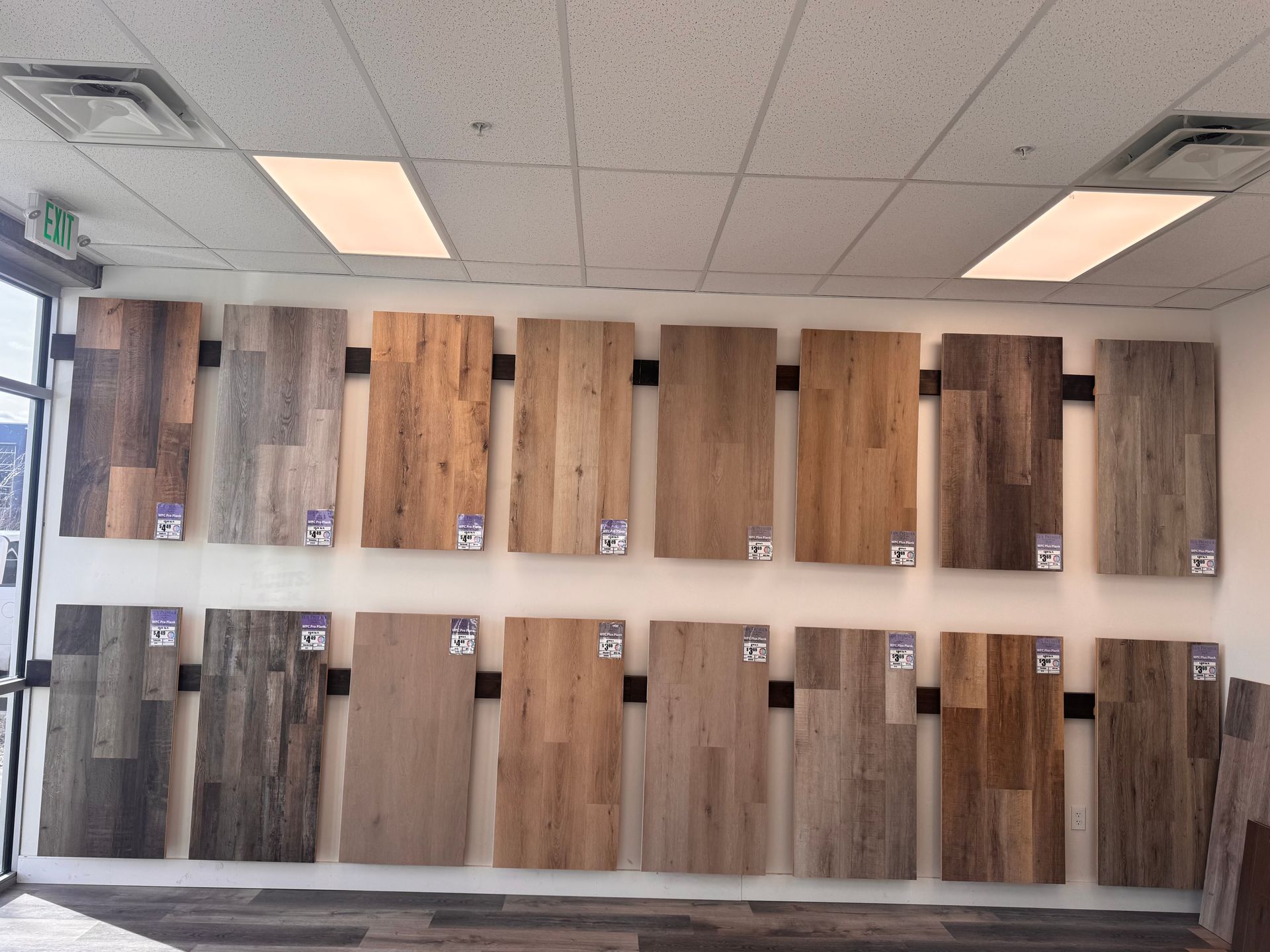 Wall display of various wood flooring samples in a showroom.