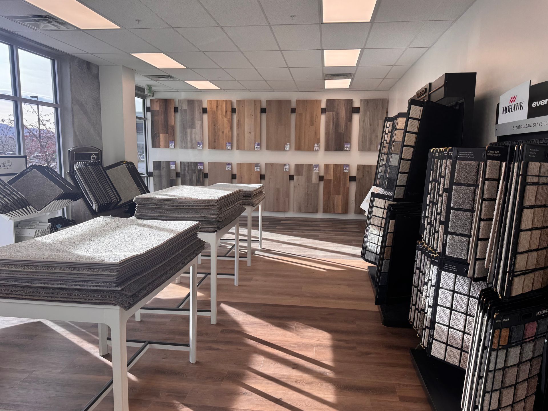 Flooring store interior with samples of wood, carpet, and tile on display.