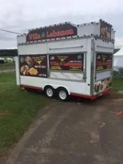 A food truck is parked on the side of the road.