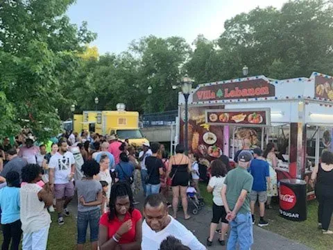A crowd of people are gathered in front of a food truck.