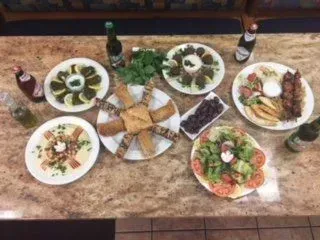A table topped with plates of food and bottles of beer.
