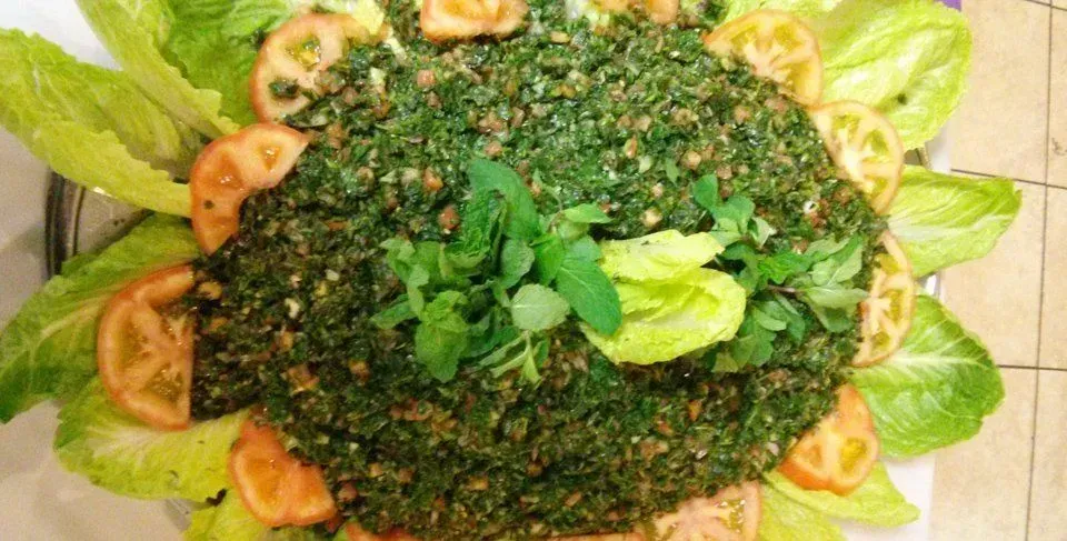 A plate of food with lettuce and tomatoes on a table.
