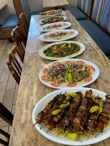 A row of plates of food on a table in a restaurant.