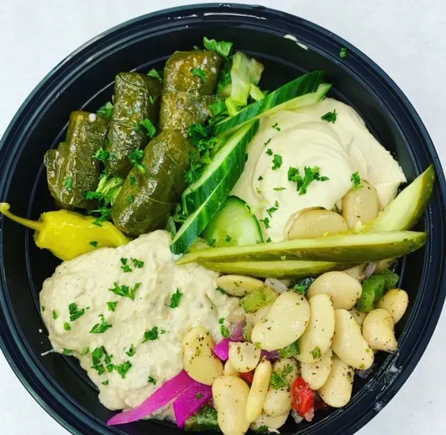 A black bowl filled with beans and vegetables.
