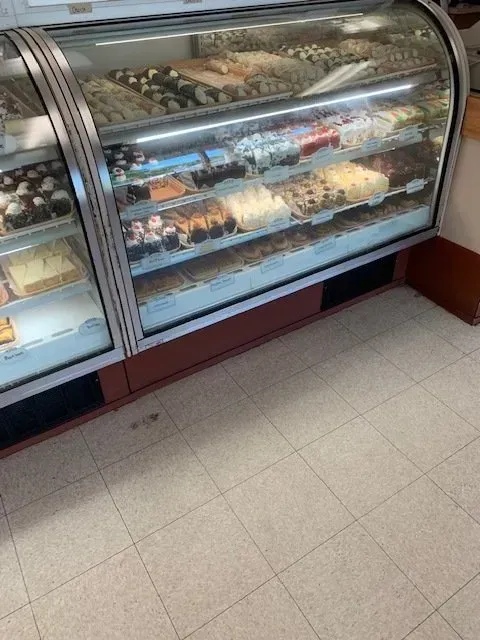 A bakery display case filled with lots of different types of desserts.