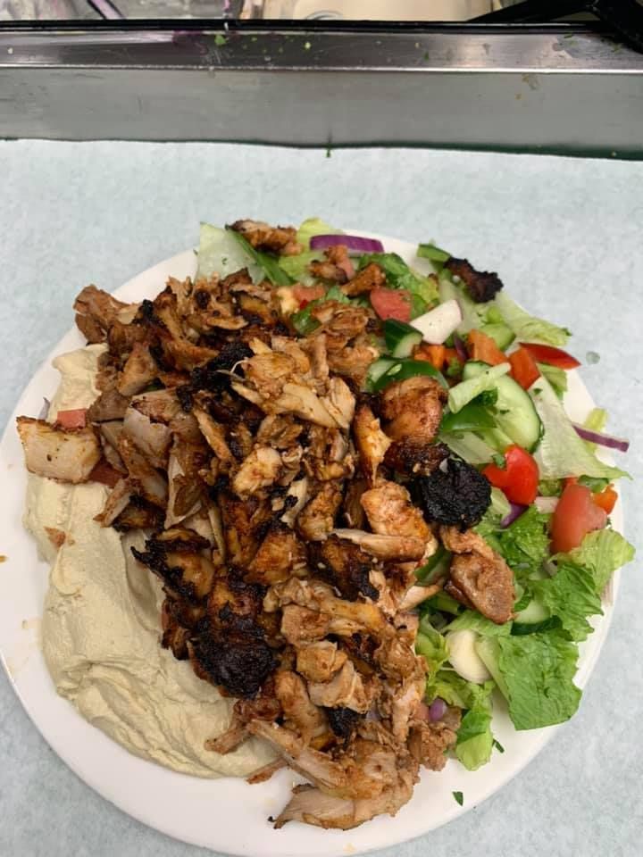 A plate of food with meat and vegetables on a table.