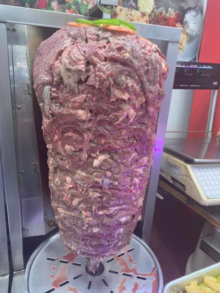 A large piece of meat is being cooked on a grill.