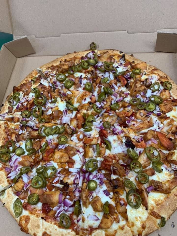 A pizza with a lot of toppings is in a box.