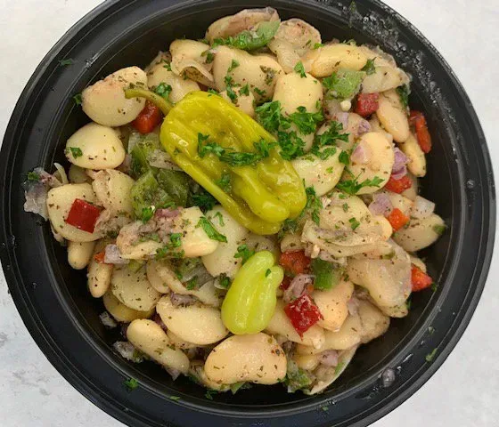 A black bowl filled with beans peppers and other vegetables.